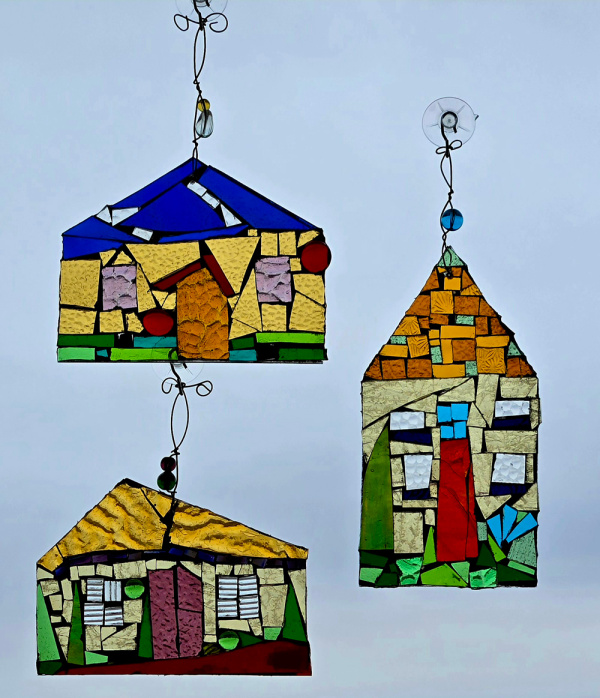 Three hanging ornaments made from colorful stained glass chips arranged to make an image of the front of a house