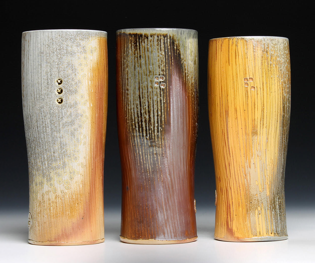 three tall yellow and earth tone brown tall goblets with vertical striations